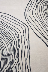 Hand-tufted wool rug in cream and black minimalist style.