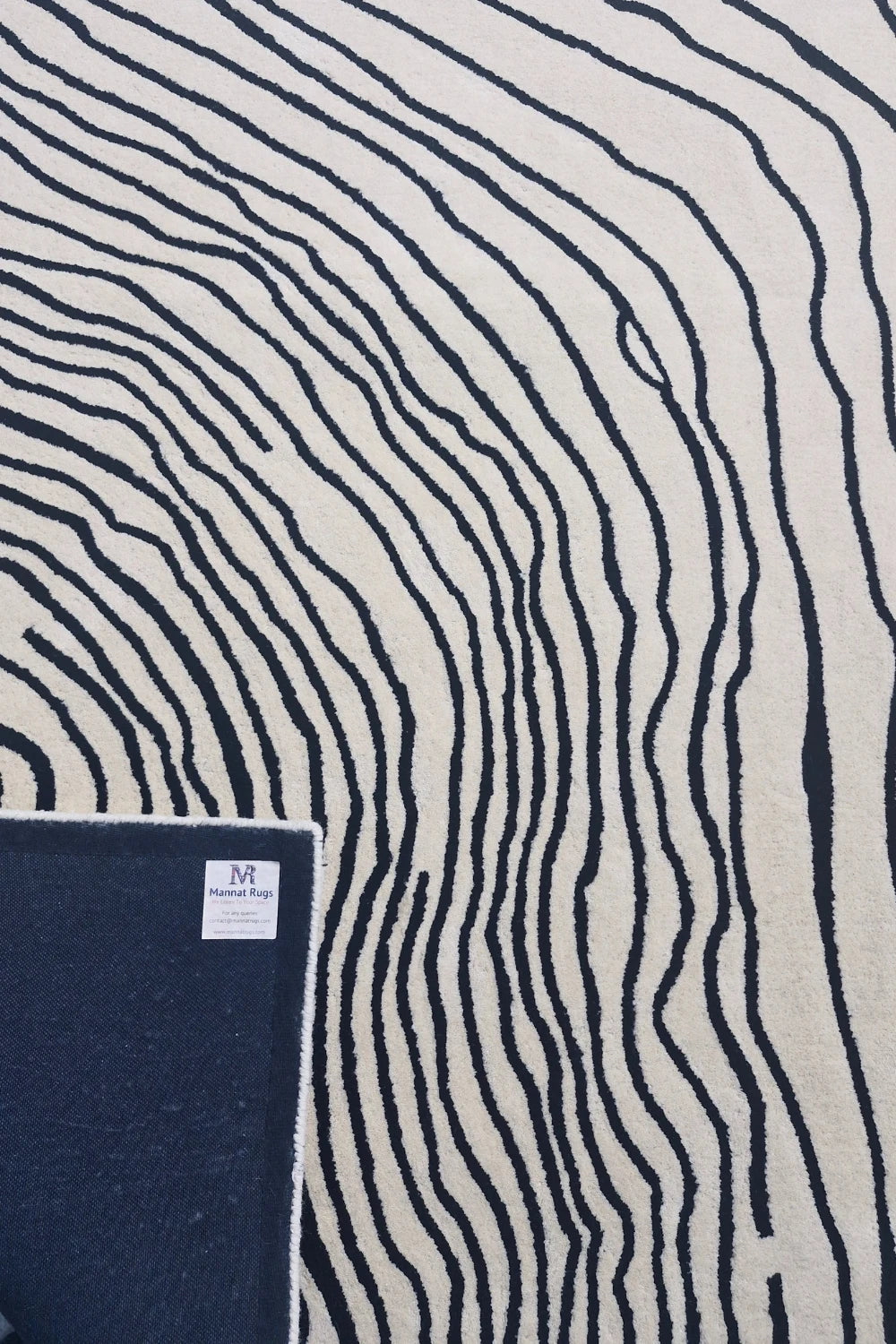 Minimalist cream wool rug with bold black abstract detailing.