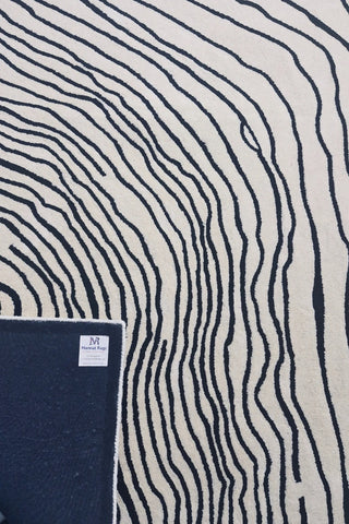 Minimalist cream wool rug with bold black abstract detailing.