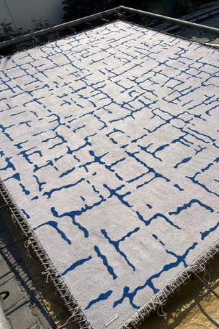 Cream and blue contemporary abstract area rug with artistic lines.