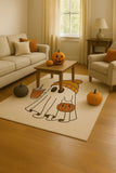 Cozy living room with beige sofa and chair, Halloween pumpkins, and a ghost-themed rug
