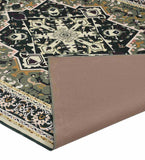 Dark green Heriz rug with intricate cream and black floral geometric patterns, corner folded to show backing