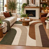 A large area rug with a mid-century modern abstract design in beige, brown, and dark green, styled in a cozy living room with a white sofa, wooden coffee table, and fireplace.