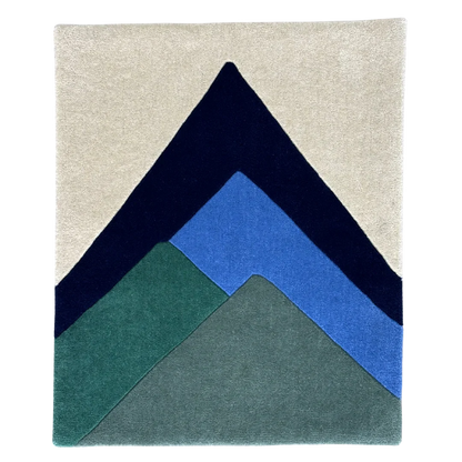 Rug with geometric mountain design in navy, blue, and green on a beige background