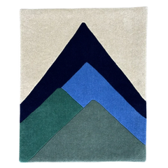 Rug with geometric mountain design in navy, blue, and green on a beige background