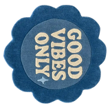 Blue flower-shaped rug with 'Good Vibes Only' text in cream, handwoven luxury design