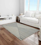 Modern gray and white geometric rug on hardwood floor in bright living room with white sofa and natural light