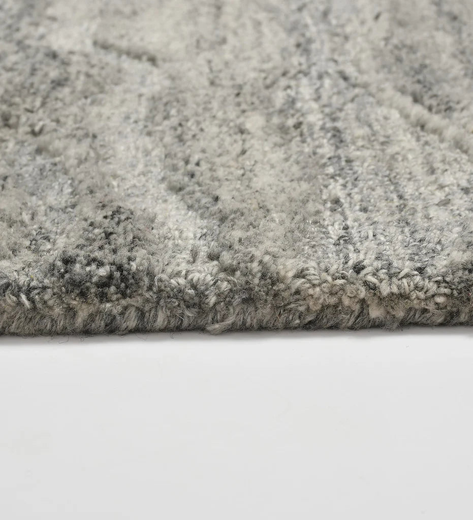 Textured grey wool rug inspired by stone and water patterns