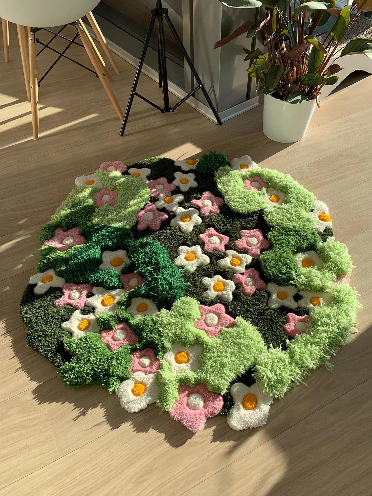 Hand-tufted green floral wool rug with sculpted moss texture and pink and white flowers