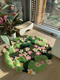 Garden-inspired hand-tufted rug featuring raised green organic shapes and blooming floral design