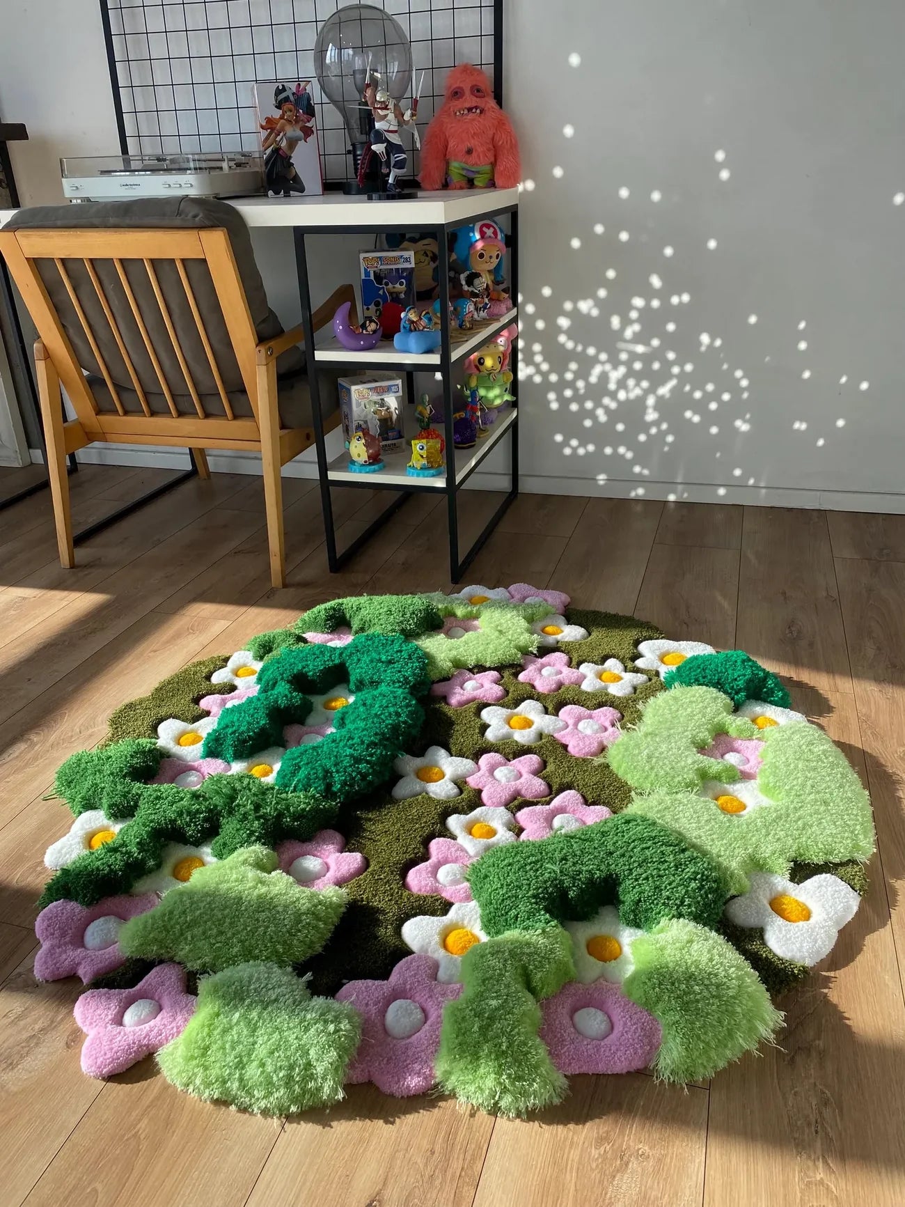 Artistic hand-tufted wool rug with layered green pile and colorful flower motifs