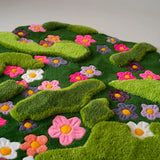 Modern bohemian hand-tufted wool rug with layered green contours and multicolor flowers