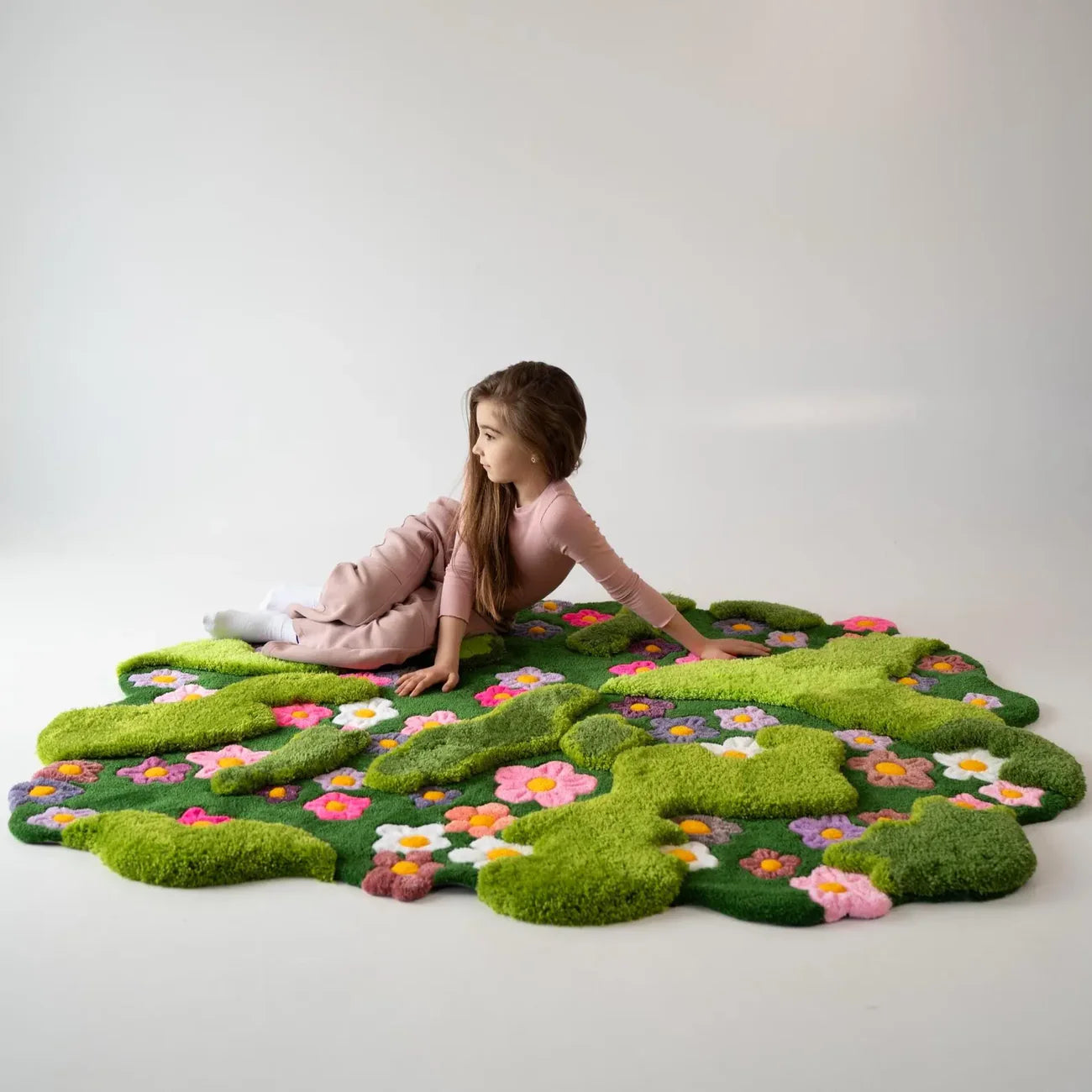 Organic shape hand-tufted wool rug featuring green landscape pattern and blooming flowers
