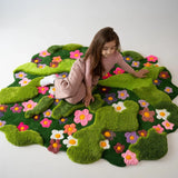 Artistic garden-inspired hand-tufted rug with sculpted green pile and vibrant floral accents