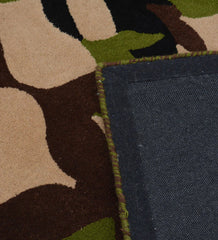 Handcrafted wool rug with green, black, and brown organic patterns