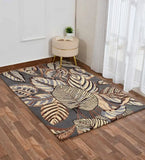 Grey floral hand-tufted wool rug on wooden floor with beige round stool and plant