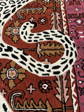 Hand-tufted luxury rug with leopard print and intricate floral patterns in warm colors