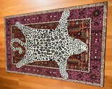 Decorative leopard print rug on traditional maroon and purple patterned area rug on hardwood floor