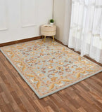 Light blue and beige traditional floral rug on wooden floor near beige ottoman and sheer curtains