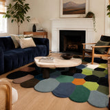 Living room with a blue sofa, coffee table, and colorful geometric rug.