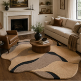 Living room with beige sofa, brown armchair, and abstract rug.

