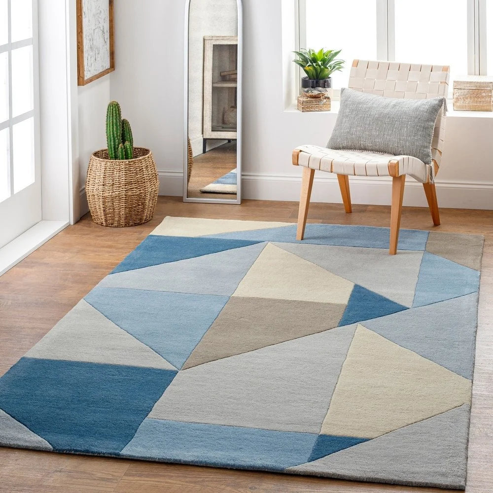 Modern wool rug with abstract angular design in soft blue tones.