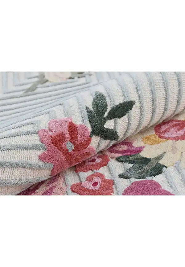 Pink and yellow flower area rug on striped background.