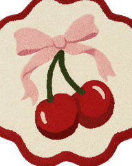 Cream and red round rug with playful cherry design and scalloped edges.