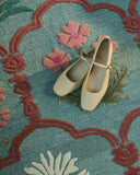 Traditional botanical rug in muted teal and red accents.