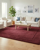 Maroon solid area rug with a minimalist border, hand-tufted texture designed for modern interiors, adding a refined and elegant accent to the space