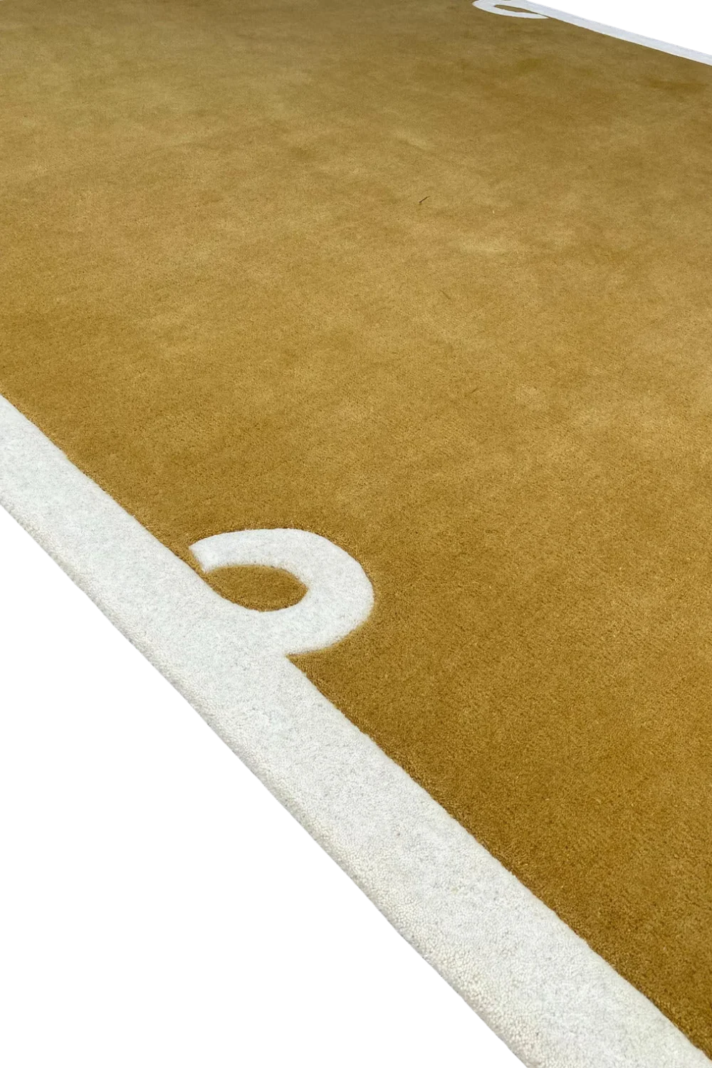Premium camel brown wool rug with subtle border detailing.