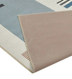 Modern Bauhaus geometric rug with blue, brown, and cream stripes folded to show beige non-slip backing