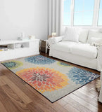 Modern floral rug with multicolor large flower patterns on wood floor in bright living room with white sofa