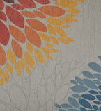 Close-up of luxury floral rug with handwoven orange, yellow, and blue leaf patterns on neutral background