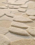 Close-up of luxury handwoven neutral-toned modern rug with organic irregular shapes and textured pattern