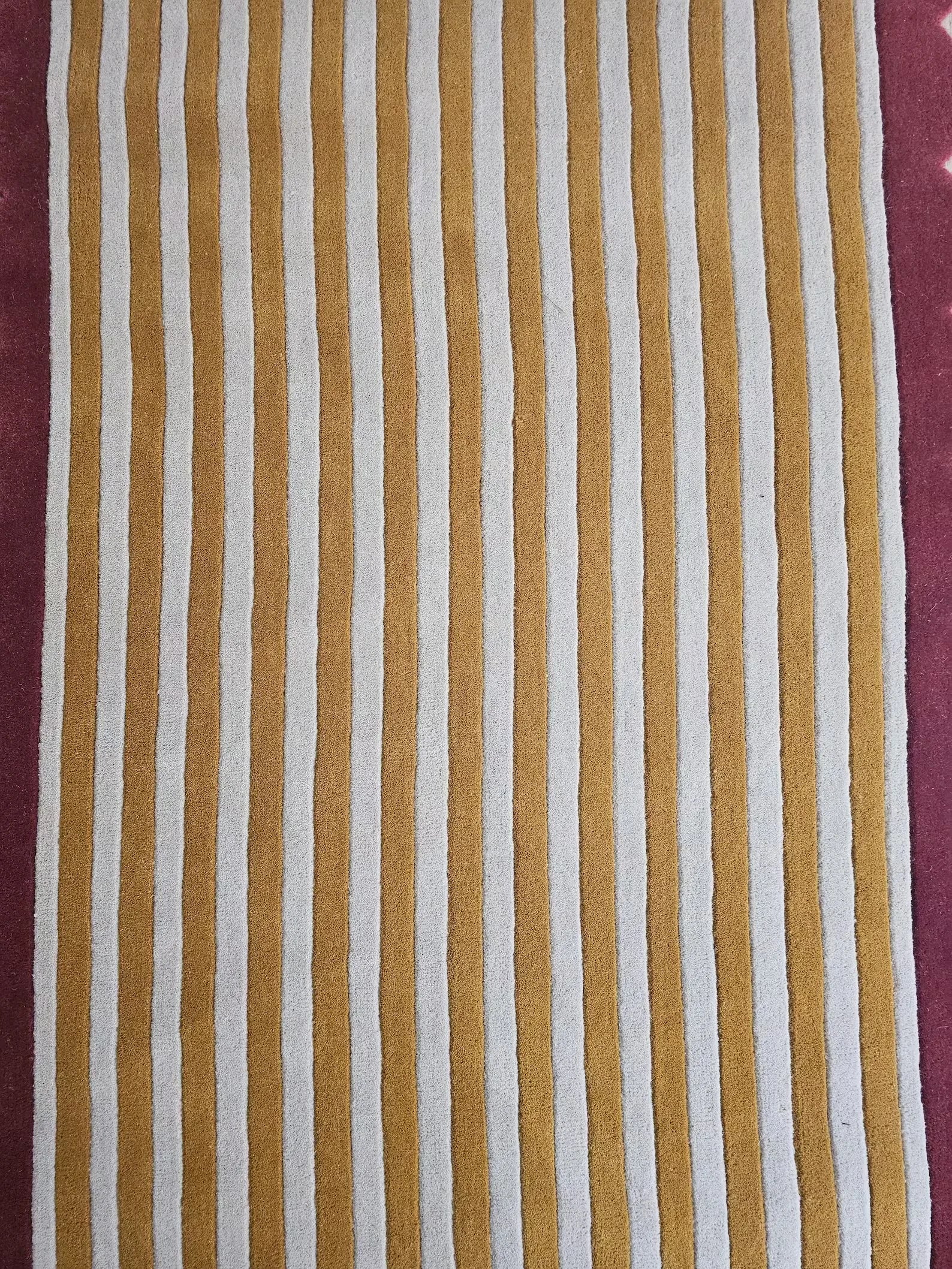 Striped fabric with brown and white stripes with a pink border