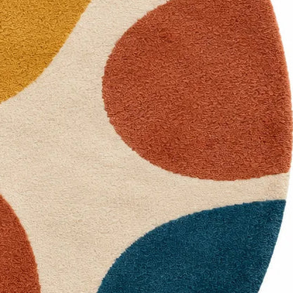 A round area rug with a retro abstract pattern of flowing wavy shapes in cream, mustard yellow, teal blue, terracotta orange, and rust red on a white background.