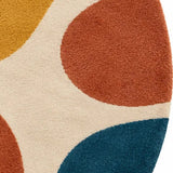 A round area rug with a retro abstract pattern of flowing wavy shapes in cream, mustard yellow, teal blue, terracotta orange, and rust red on a white background.