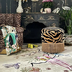 Hand-tufted rug with oriental bird and floral design in multicolor on white background, bordered in black Greek key pattern.