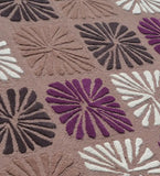 Close-up of a multicolor wool rug with raised floral block patterns in purple, brown, white, and dark tones