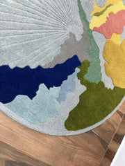 Luxury hand-tufted rug with grey, blue, mustard, and olive accents.