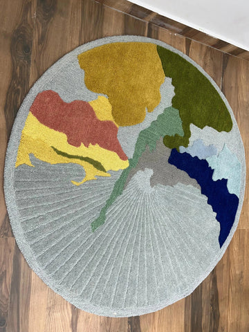 Color-block pattern circular hand-tufted rug on wooden floor.