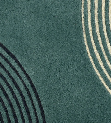 Close up of  Hand-tufted wool rug with colorful arched geometric lines in teal, mustard, black, and beige.