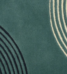 Close up of  Hand-tufted wool rug with colorful arched geometric lines in teal, mustard, black, and beige.