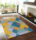 Modern geometric prism area rug with multicolor blue, yellow, gray shapes on hardwood floor