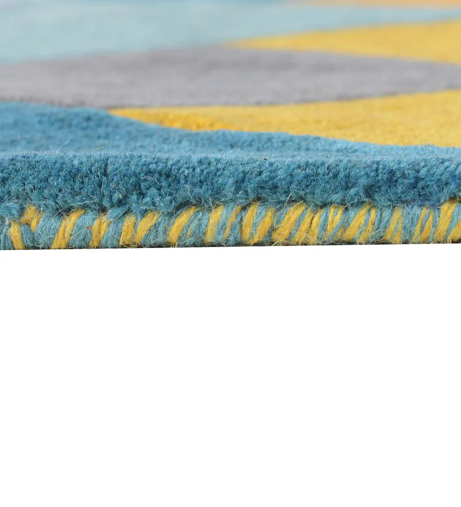 Pile thickness and closeup of Colorful geometric wool rug with mustard yellow, teal, grey, and lavender tones in an abstract prism pattern.