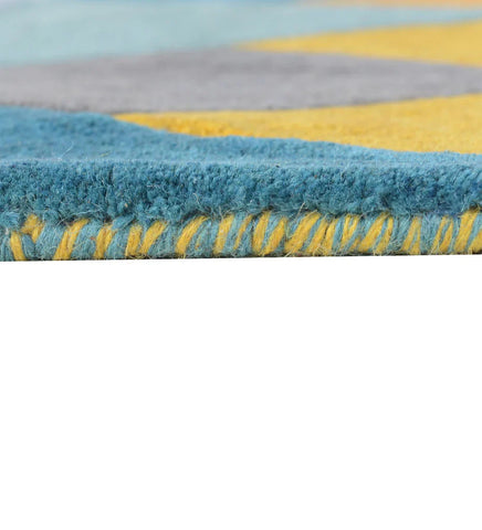 Pile thickness and closeup of Colorful geometric wool rug with mustard yellow, teal, grey, and lavender tones in an abstract prism pattern.