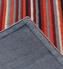Handcrafted striped rug in red, orange, and grey tones