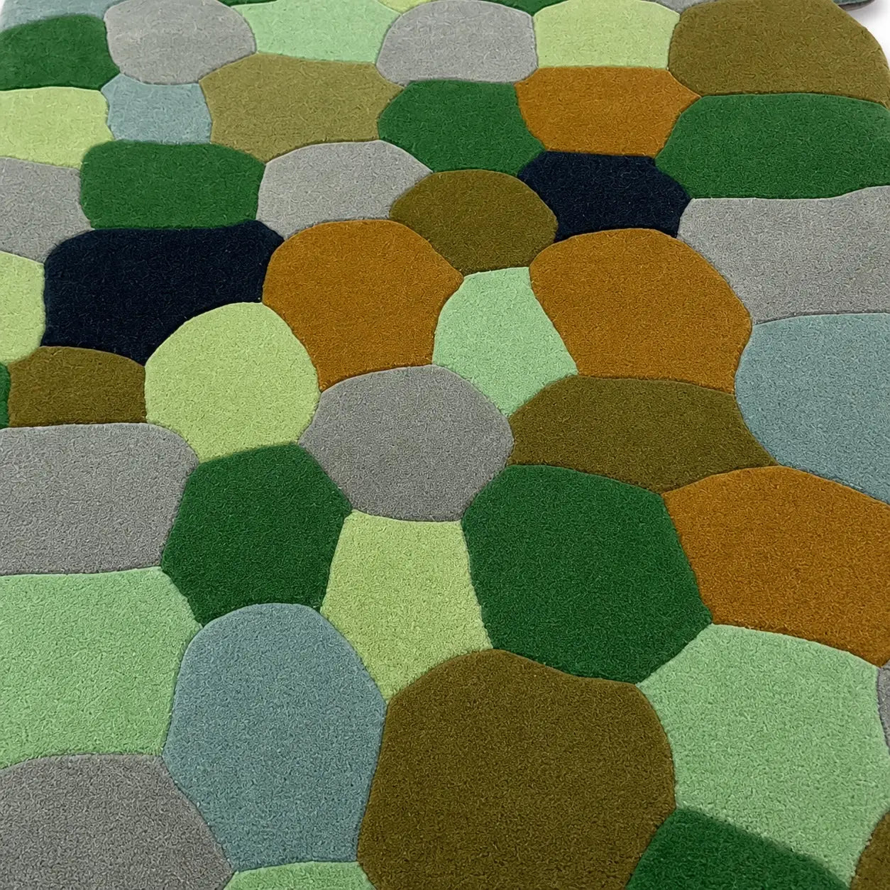 Multicolored textured surface with circular patterns in various shades of green, brown, and gray.