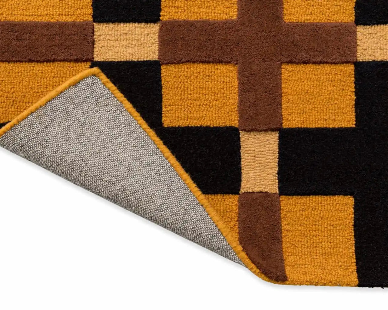 Close-up of a geometric patterned rug with brown, orange, and black squares.